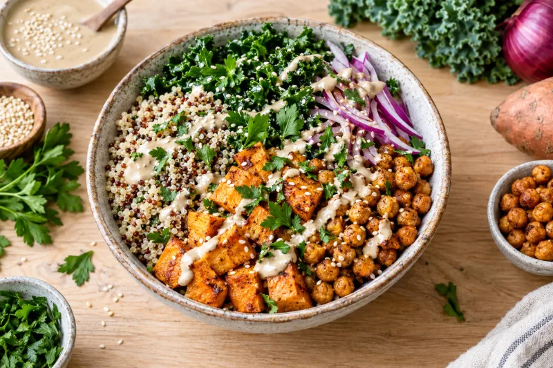 Vegane Grünkohl Quinoa Bowl mit gerösteter Süßkartoffel, Kichererbsen und Tahini-Dressing in einer Schüssel