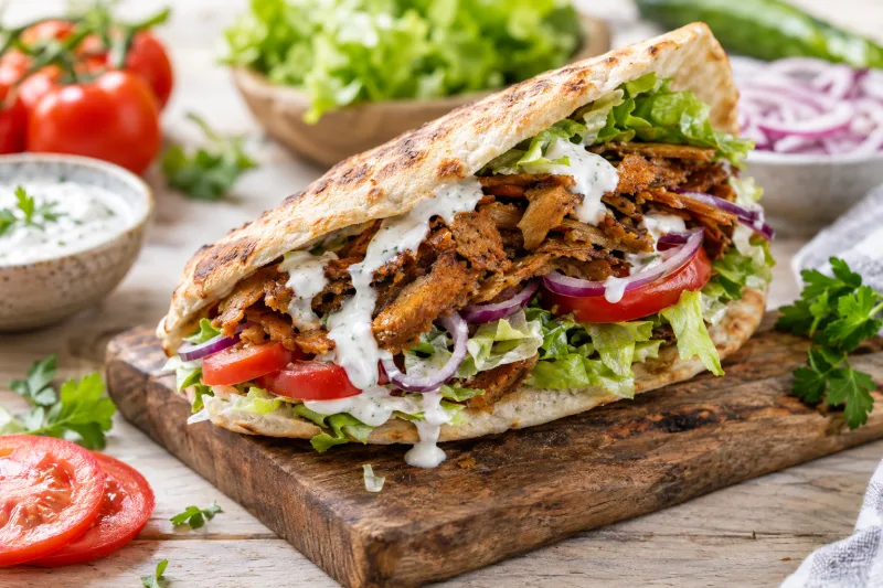 Veganer Döner im Fladenbrot mit Seitanstreifen, Tomaten, roten Zwiebeln und Knoblauchsoße