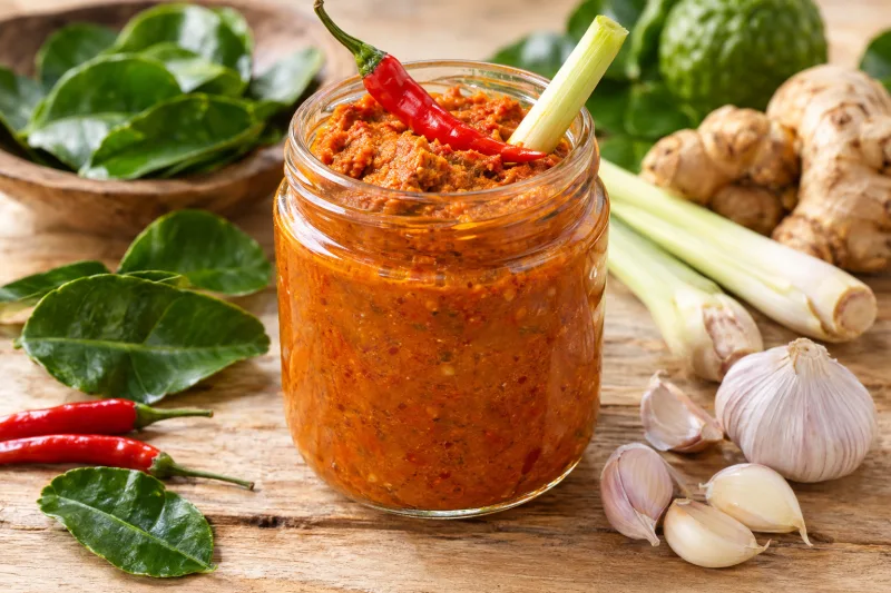Javanische Currypaste in einem Glas mit frischen Zutaten drumherum