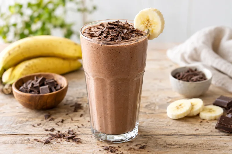 Veganer Schokoladen-Shake in einem Glas mit Schokoraspeln garniert