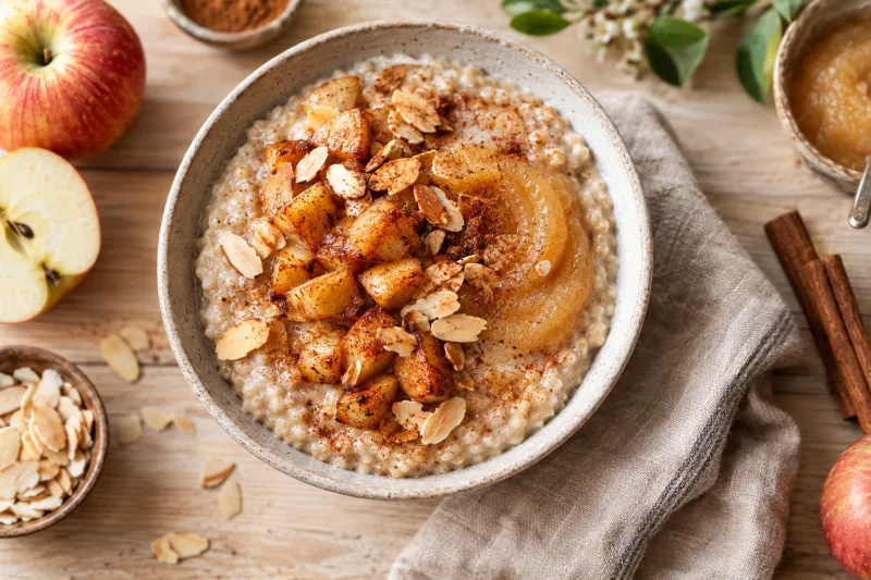 Veganes Apfel-Zimt-Porridge in einer Schale mit Apfelwürfeln, Zimt und gerösteten Mandeln