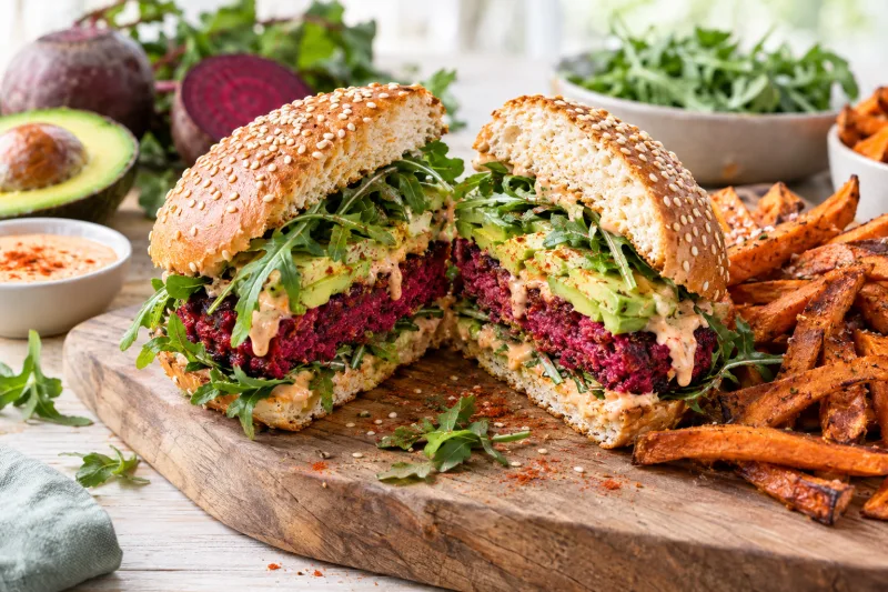 Veganer Rote-Bete-Burger mit Avocado und Rucola auf einem Teller