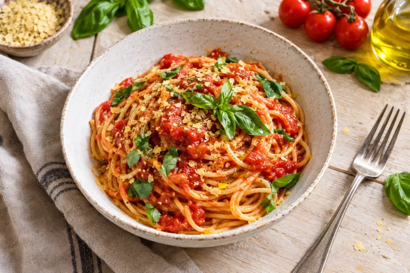 Teller Spaghetti mit roter Tomatensauce und frischem Basilikum